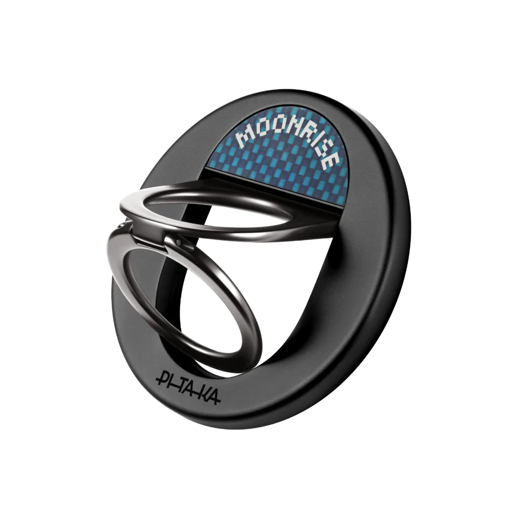 Pitaka MagEZ Grip – حلقة مسند هجينة بتصميم فائق النحافة، دعم كامل لمنظومة MagSafe، وخامات فاخرة من ألياف الأراميد والزنك حلقة ومسند مغناطيسي ذكي للهواتف الذكية، مصمّم بأسلوب الـ Minimal النحيف جداً، يجمع بين قوة التثبيت المغناطيسي والأناقة العالية بفضل استخدام خامات عسكرية الصنع خفيفة الوزن. الميزات الأساسية: ✅ تصميم فائق النحافة وخفة الوزن الدائمة: تتميز الحلقة بهيكل هندسي مدمج بسماكة دنيا تبلغ 4.3 مم فقط ووزن لا يتعدى 30 غراماً، مما يتيح وضع الهاتف في الجيب بسلاسة دون إضافة أي حجم مزعج. ✅ قوة تثبيت مغناطيسي حديدية (تصل لـ 1.2 كجم): مدعومة بمغناطيسات N52 القوية والمتوافقة تماماً مع أنظمة MagSafe وMagEZ 2.0، مما يضمن التثبيت الفوري الآمن على الحافظات دون الخوف من سقوط الهاتف أثناء استخدامه بيد واحدة. ✅ مسند مزدوج وتثبيت مستقر في كل الوضعيات: مصنعة بهيكل من سبيكة الزنك المتينة مع تصميم حلقة مزدوجة (Double-ring) يوفر دعماً ثابتاً للهاتف، لتشغيله كمسند في الوضع الأفقي (Landscape) أو العمودي (Portrait) لراحة اليدين. ✅ خامات فاخرة وصديقة للبيئة (ألياف الأراميد): يدمج التصميم الخارجي بين ألياف الأراميد المقاومة للاهتراء والخدوش (المعاد تدويرها من بقايا تصنيع إطارات الكاميرات) مع طبقة طلاء مطاطية ناعمة توفر ملمساً فاخراً ومريحاً للإصبع. ✅ حماية إضافية لعدسات الكاميرا الخلفية: عند وضع الهاتف على المكتب، تعمل سماكة الحلقة الممتدة (حتى 5.9 مم عند الأطراف) على رفع جسم الهاتف ذكيًا، مما يمنع احتكاك عدسات الكاميرا بالأسطح ويحميها من الخدش. المواصفات التقنية: النوع: حلقة إمساك ومسند مغناطيسي ذكي (Magnetic Phone Ring Holder & Stand) مواد الصنع: ألياف الأراميد الفاخرة (600D Aramid Fiber) + سبيكة الزنك (Zinc Alloy) + طلاء إلكتروستاتيكي مقاوم للخدش التوافق المغناطيسي: متوافق بالكامل مع MagSafe (Apple) ومنظومات MagEZ 2.0 (Pitaka) قوة الجذب المغناطيسي: قوة سحب هائلة تصل إلى 1.2 كجم لثبات مطلق أبعاد الهيكل: الحد الأدنى للسماكة: 4.3 مم (يصل إلى 5.9 مم) | الحد الأدنى للوزن: 30 غراماً آلية الاستخدام: حلقة إمساك مانعة للسقوط + حامل قابل للتعديل بزوايا رؤية متعددة التوافق مع الحافظات: يركب مباشرة على حافظات سلسلة Edge وSumma وجميع أغطية المغناطيس المخصصة لهواتف الآيفون، وجالاكسي، وجوجل بكسل